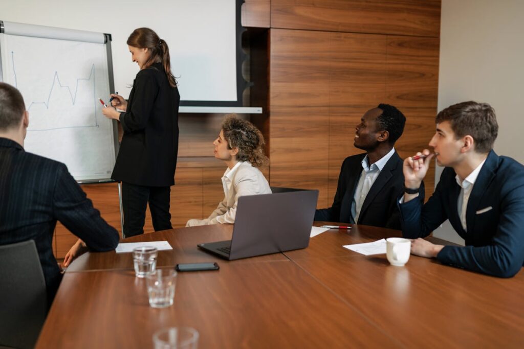 Man in Black Suit Sitting beside his Colleagues