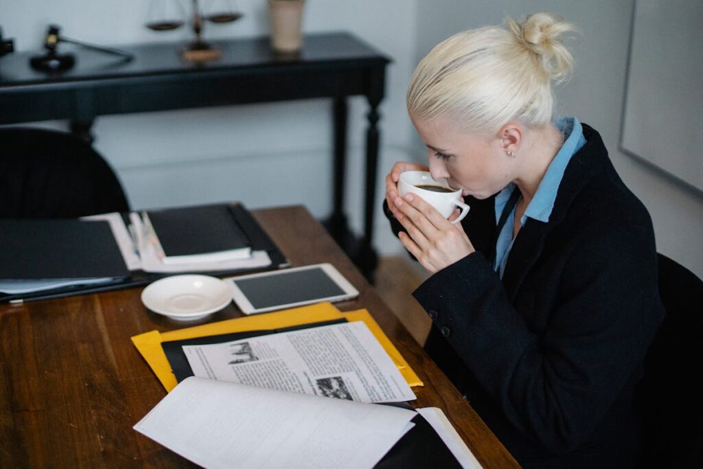 male Lawyer Drinking Coffee while reading a Case