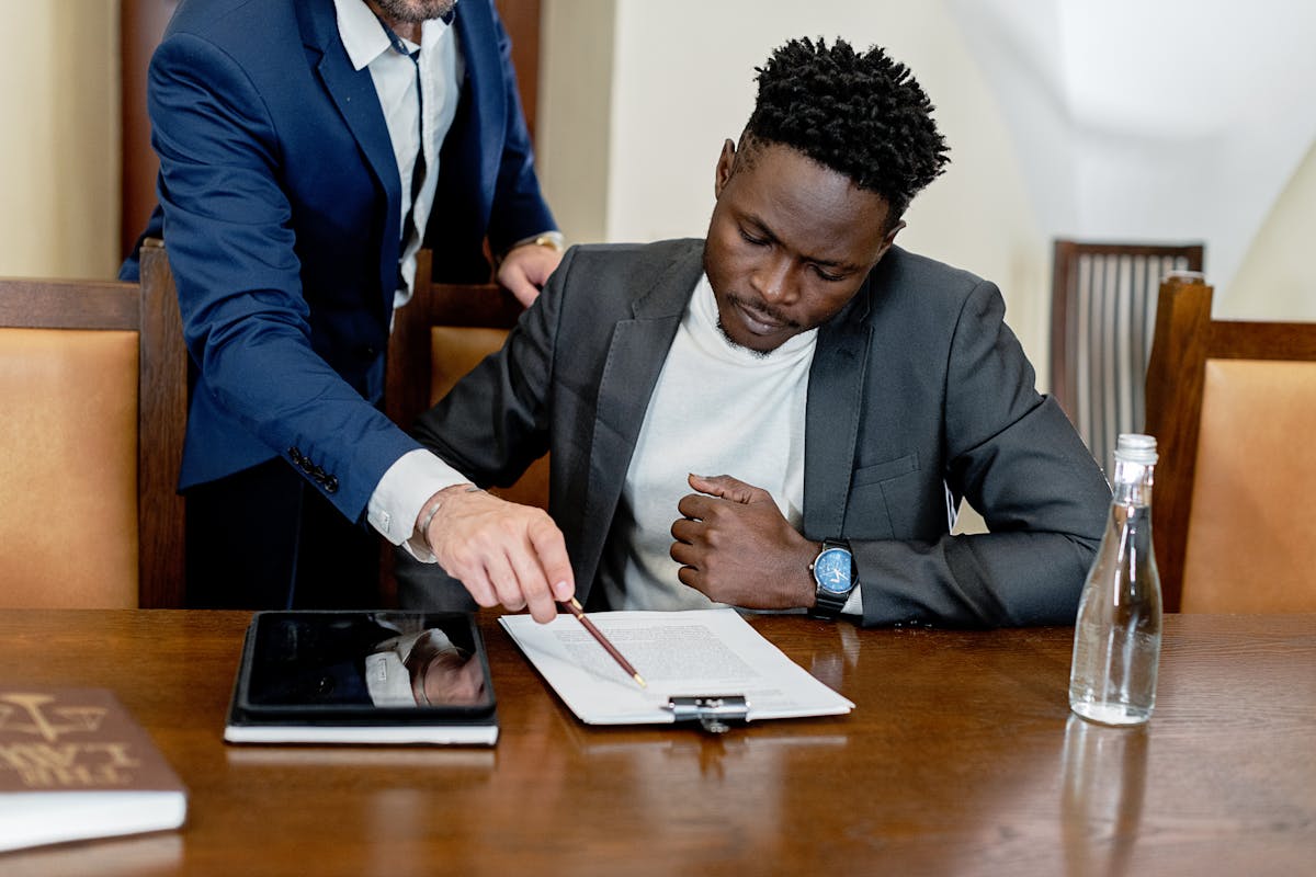 A Man in Gray Suit Looking at the Document on the Table