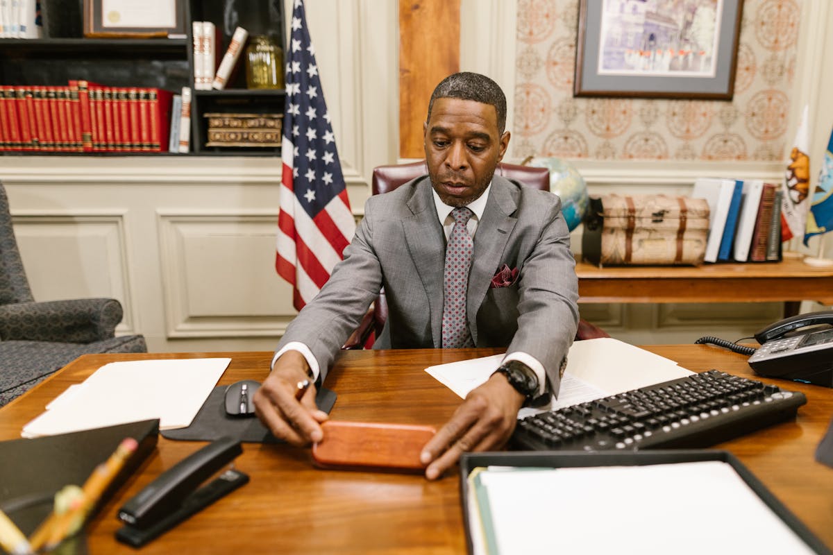 Man in Gray Suit Jacket Sitting on Chair in Front of Laptop Computer