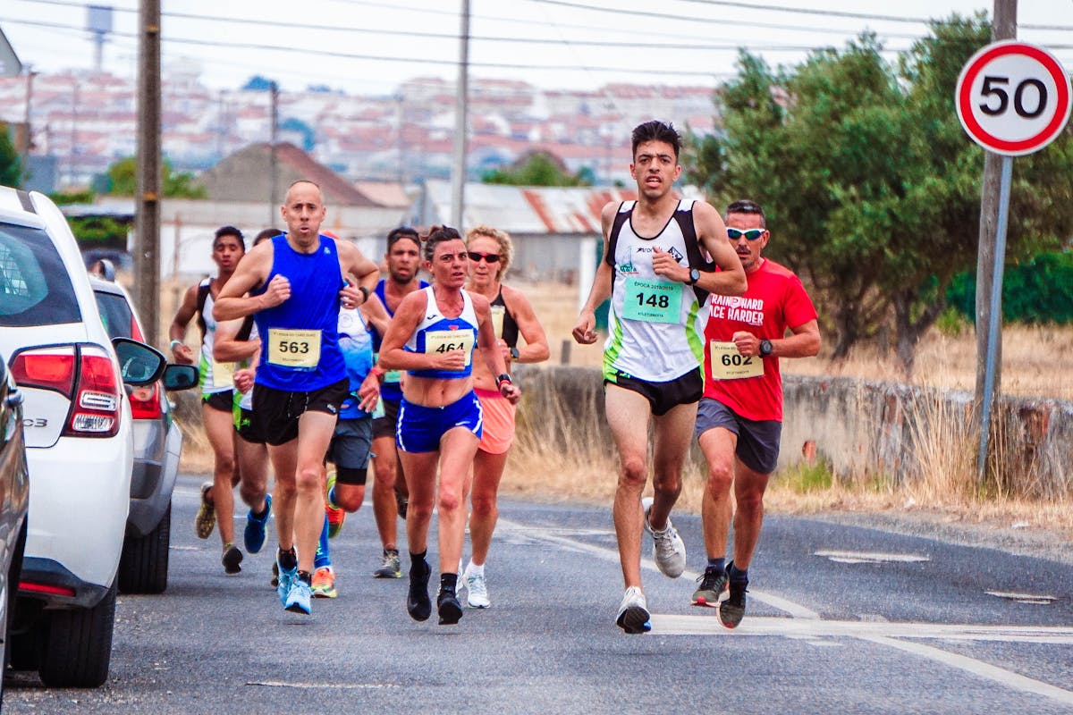 Photo of People Running Beside Parked Vehicles