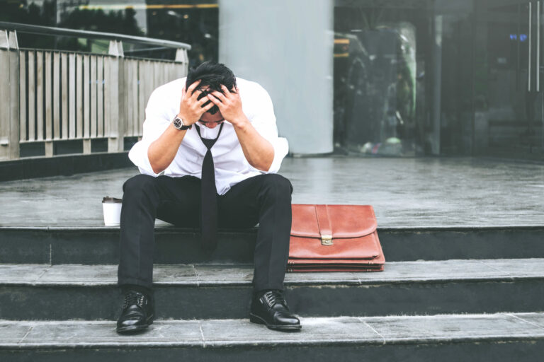 Unemployed Tired or stressed businessman sitting on the walkway after work Stressed businessman concept